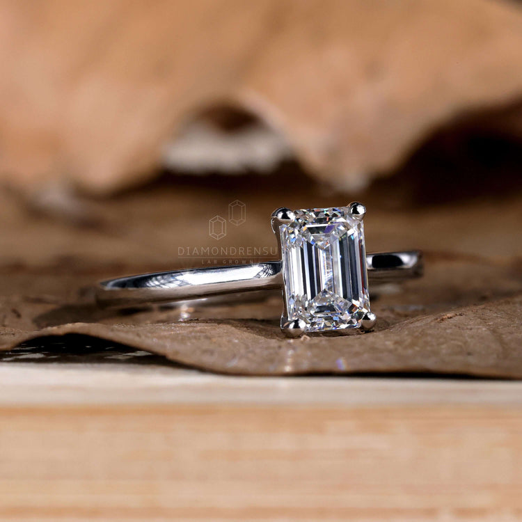 Solitaire emerald cut ring with a modern, sleek design.