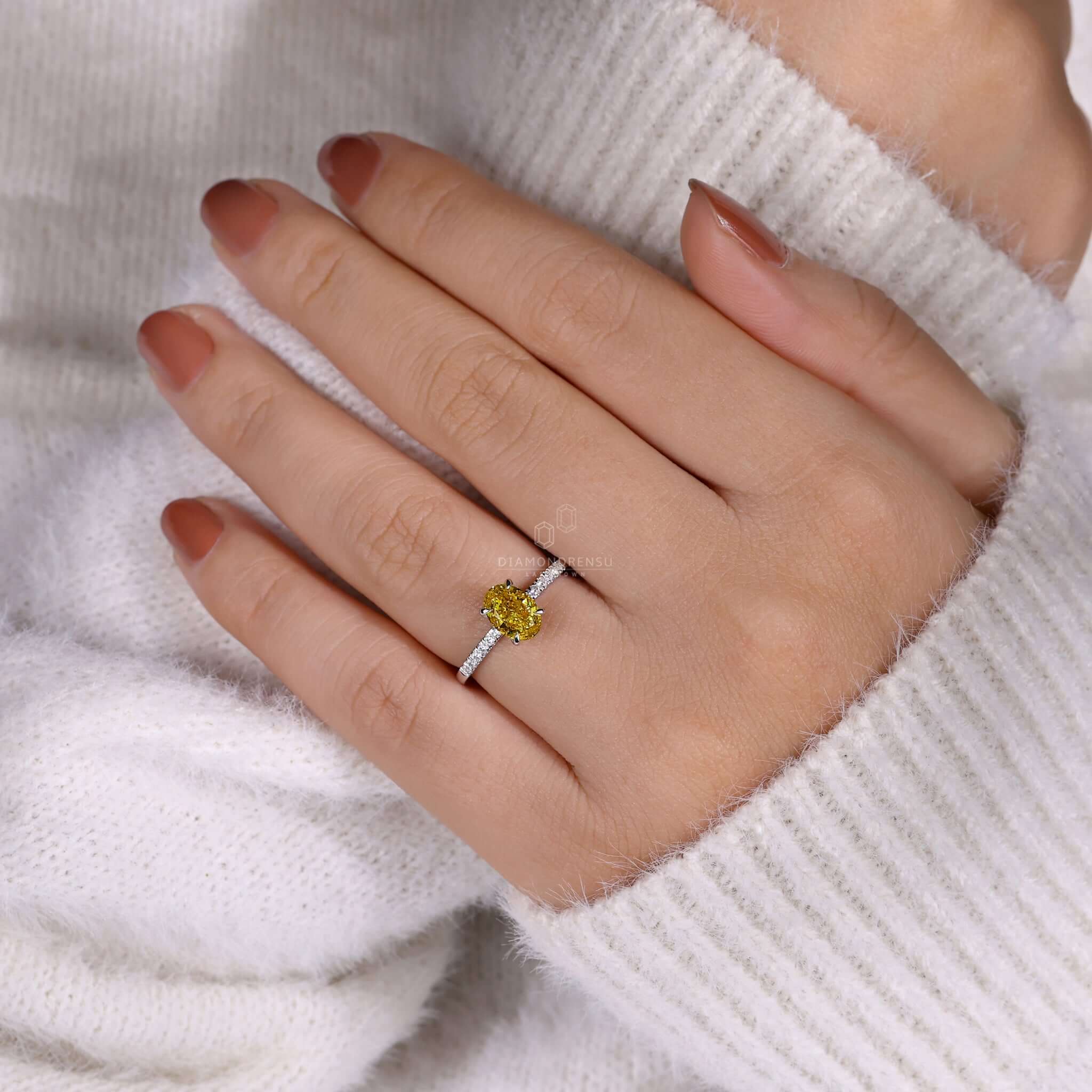 Oval yellow diamond engagement ring with a hidden halo and claw prong setting for a luxurious touch.