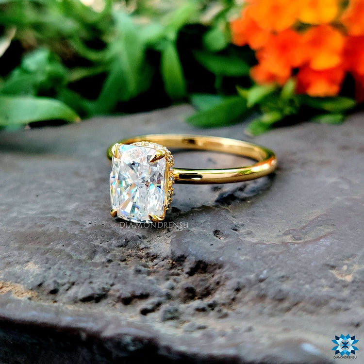 Hidden halo engagement ring with cushion cut moissanite center.