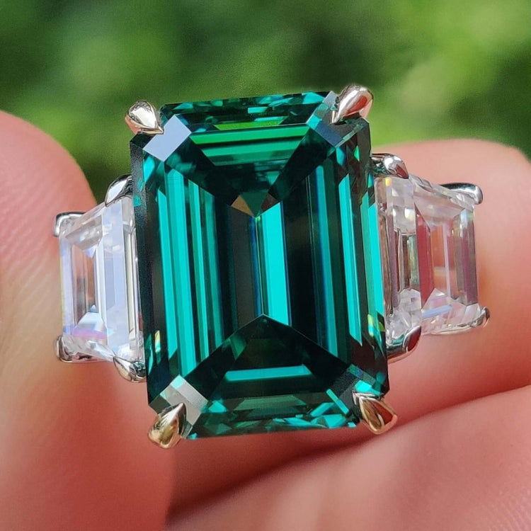 Green emerald ring with emerald cut moissanite center.