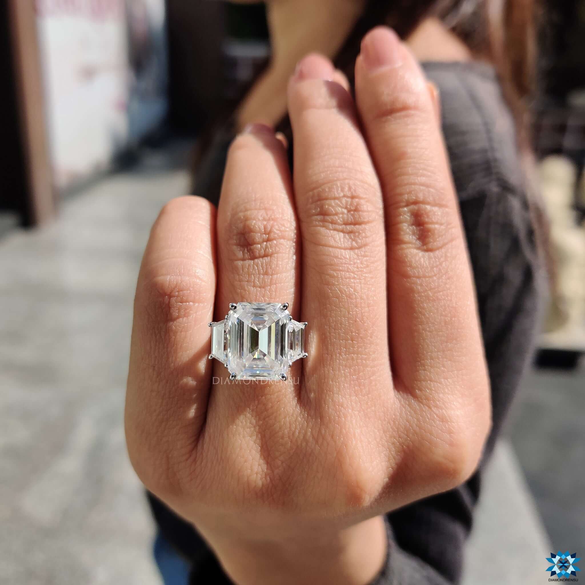 Emerald cut center stone with trapezoid side stones.