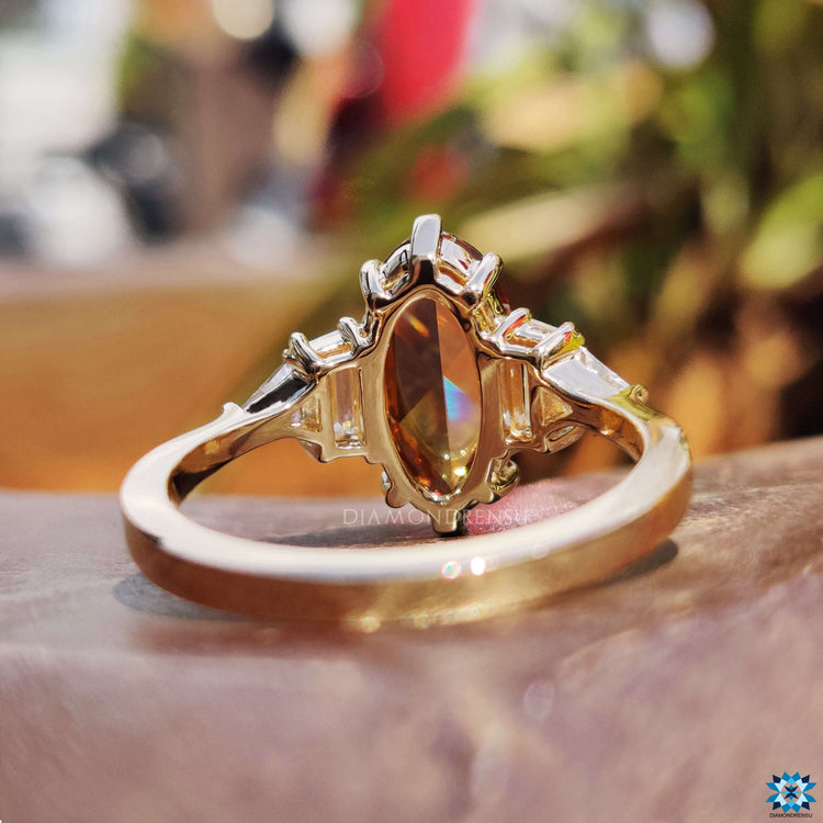 6 prong claw setting holding champagne moissanite.