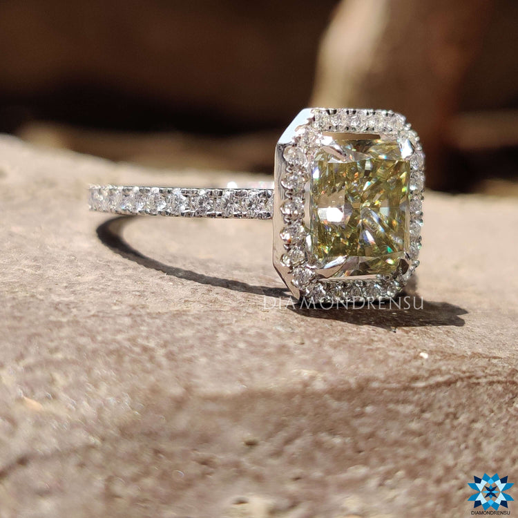 Halo setting ring crafted in white gold with moissanite and pave detailing.