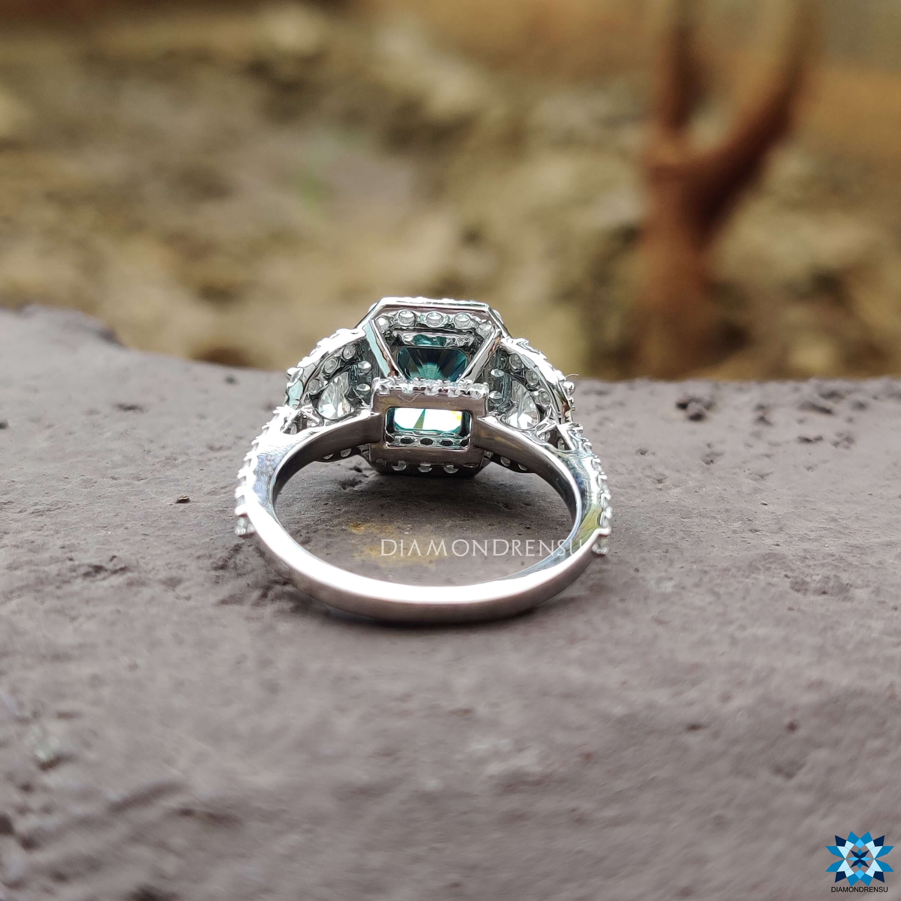 Custom halo ring with blue moissanite and side stones.