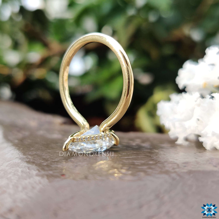 Handmade pear shaped moissanite ring in yellow gold.
