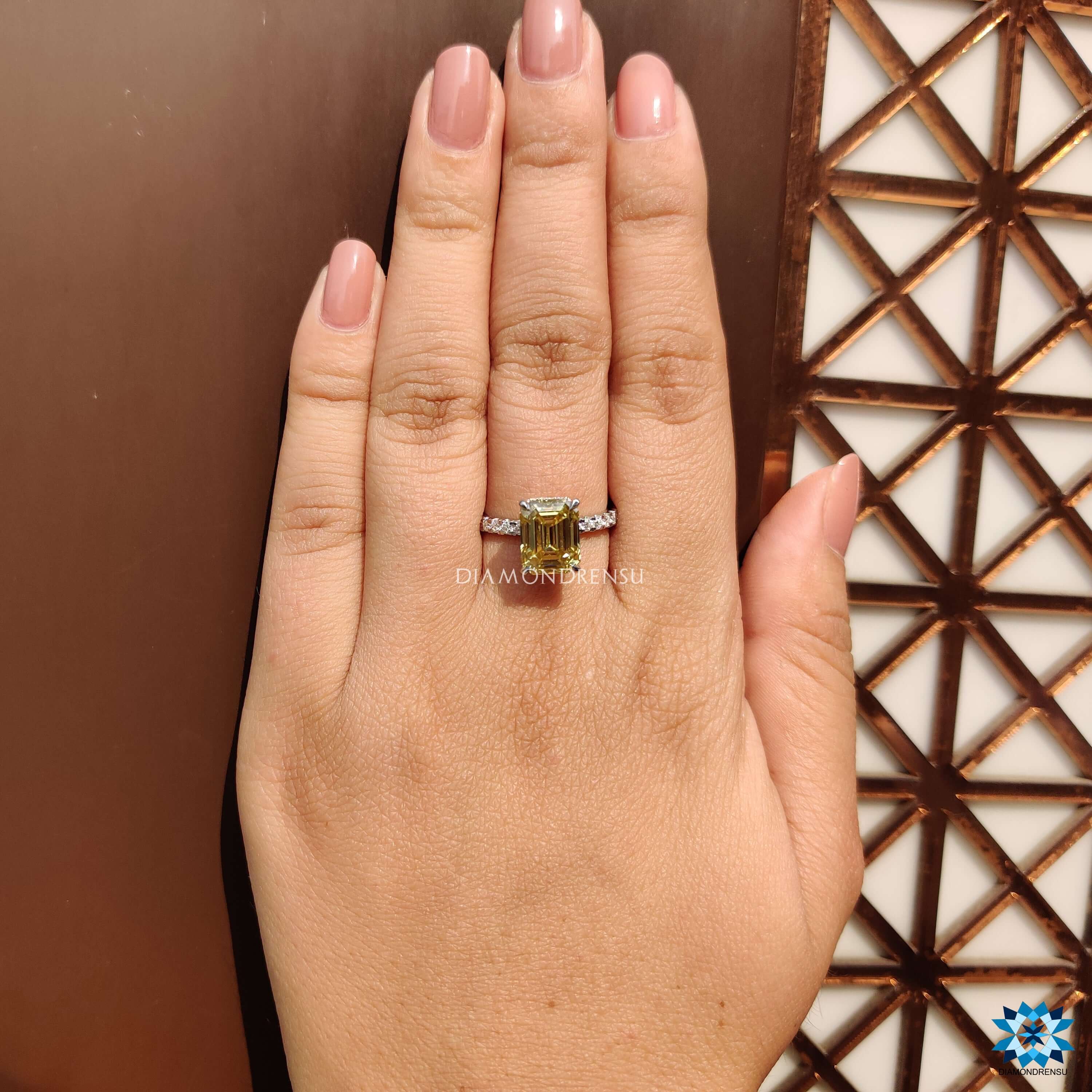 Emerald cut moissanite engagement ring in rich yellow tone.