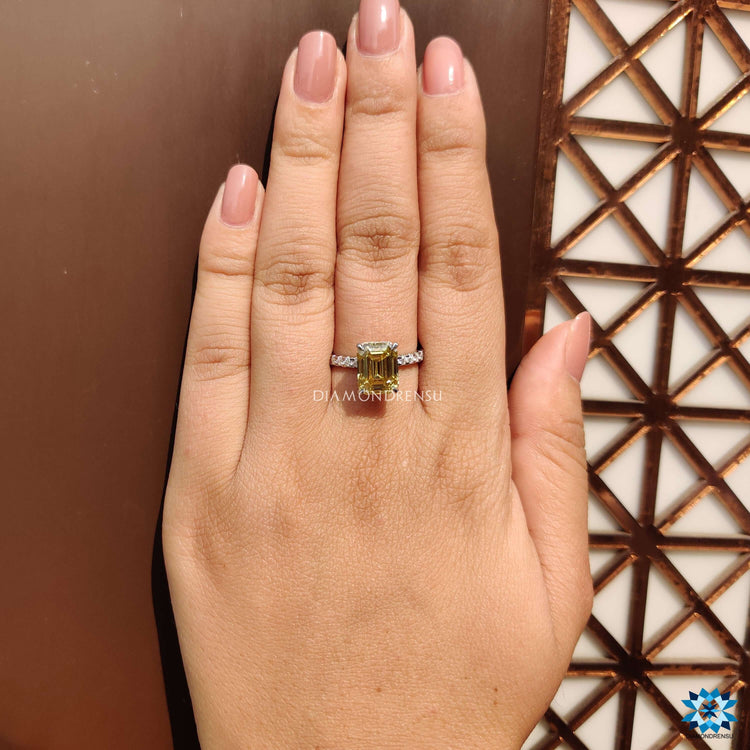 Emerald cut moissanite engagement ring in rich yellow tone.