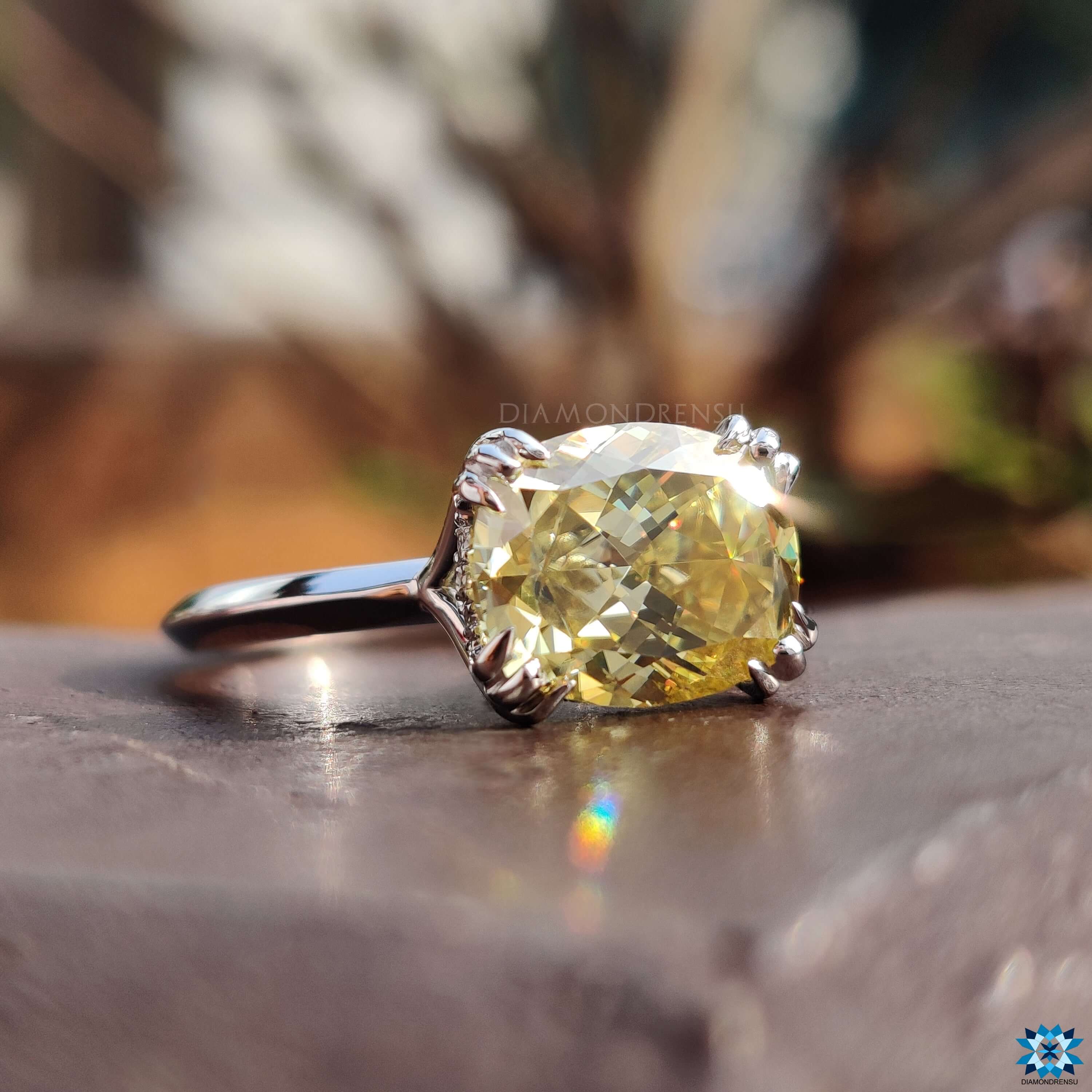 East west moissanite ring with cushion cut center stone.