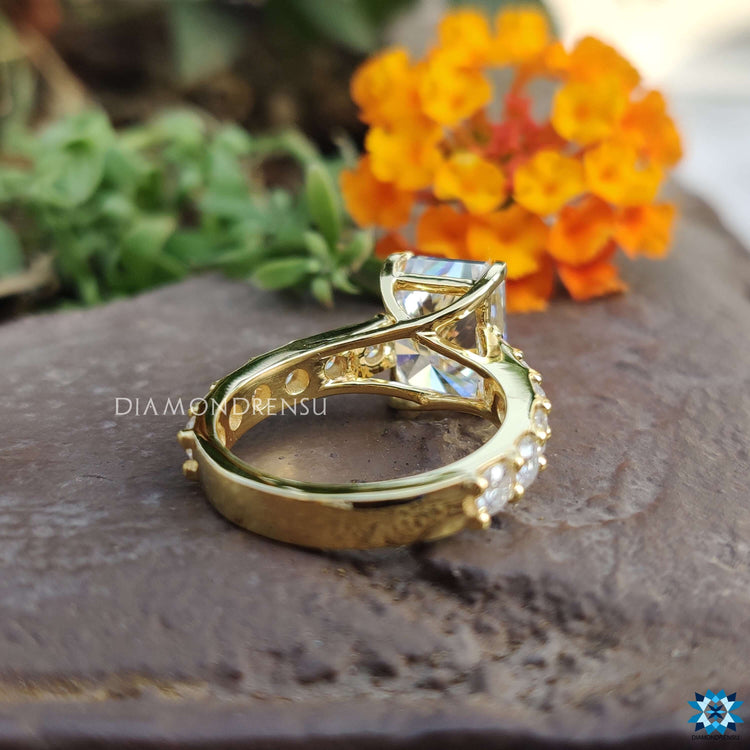 Four prong moissanite ring in yellow gold band.