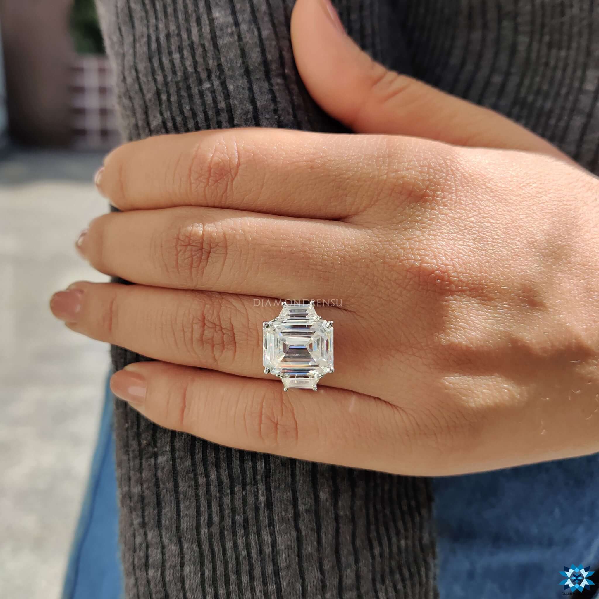 Emerald cut moissanite center with side accents.