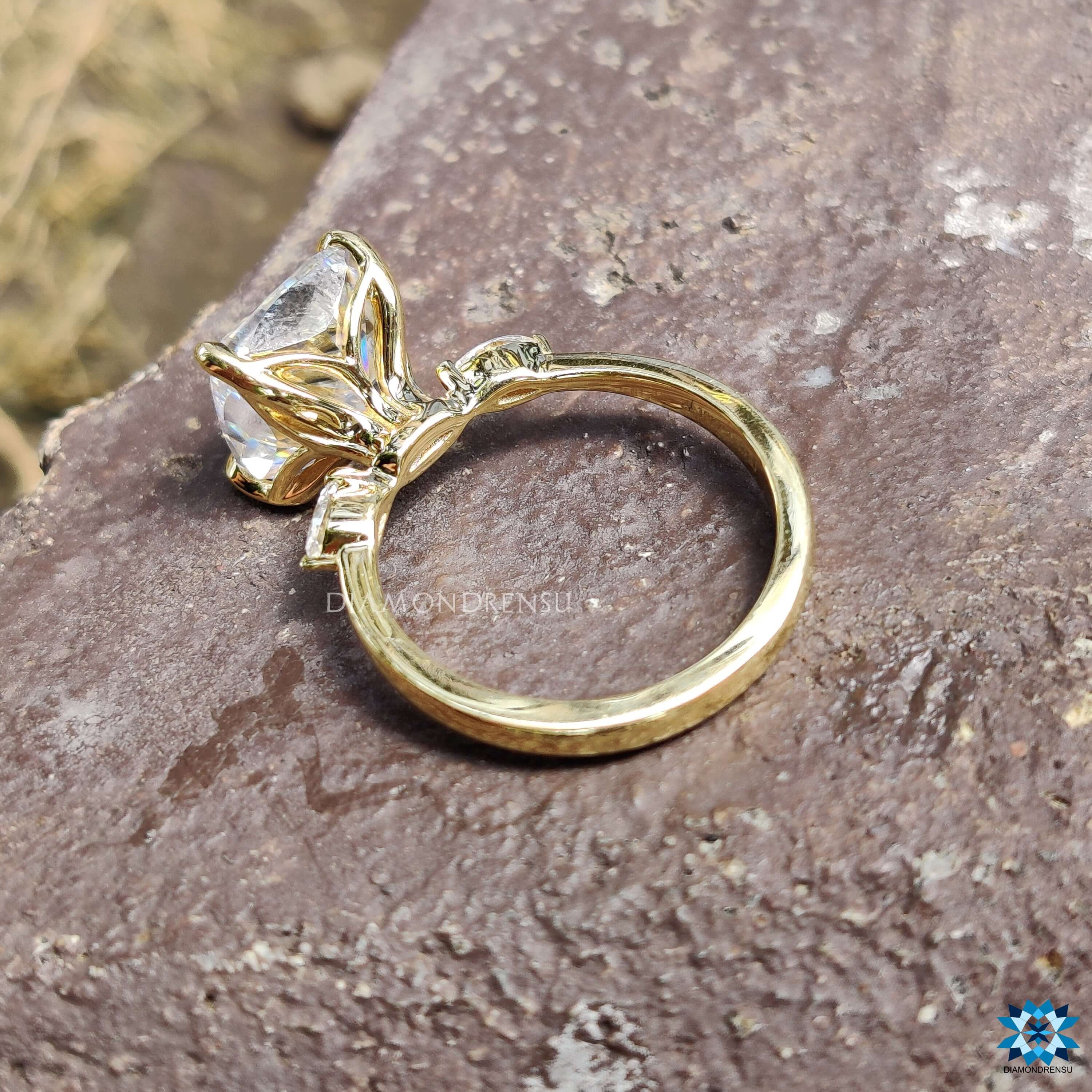 3 stone ring with moissanite cushion and pear cuts set in yellow gold.