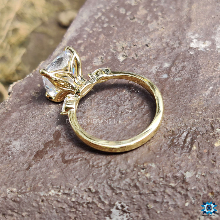 3 stone ring with moissanite cushion and pear cuts set in yellow gold.