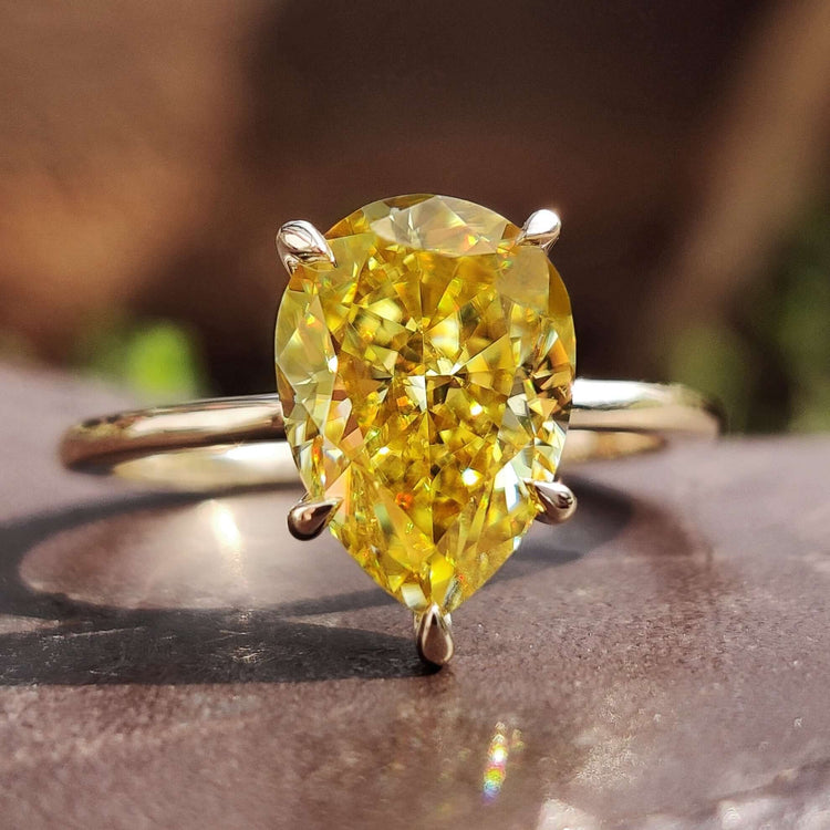 Pear solitaire engagement ring with canary yellow moissanite.