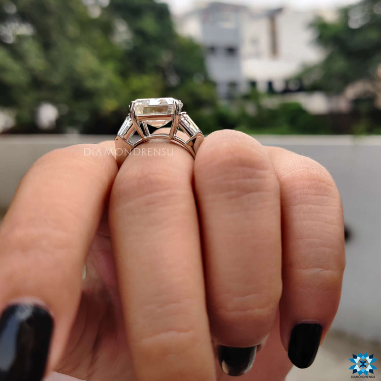 Moissanite ring featuring emerald and tapered bullet cuts.