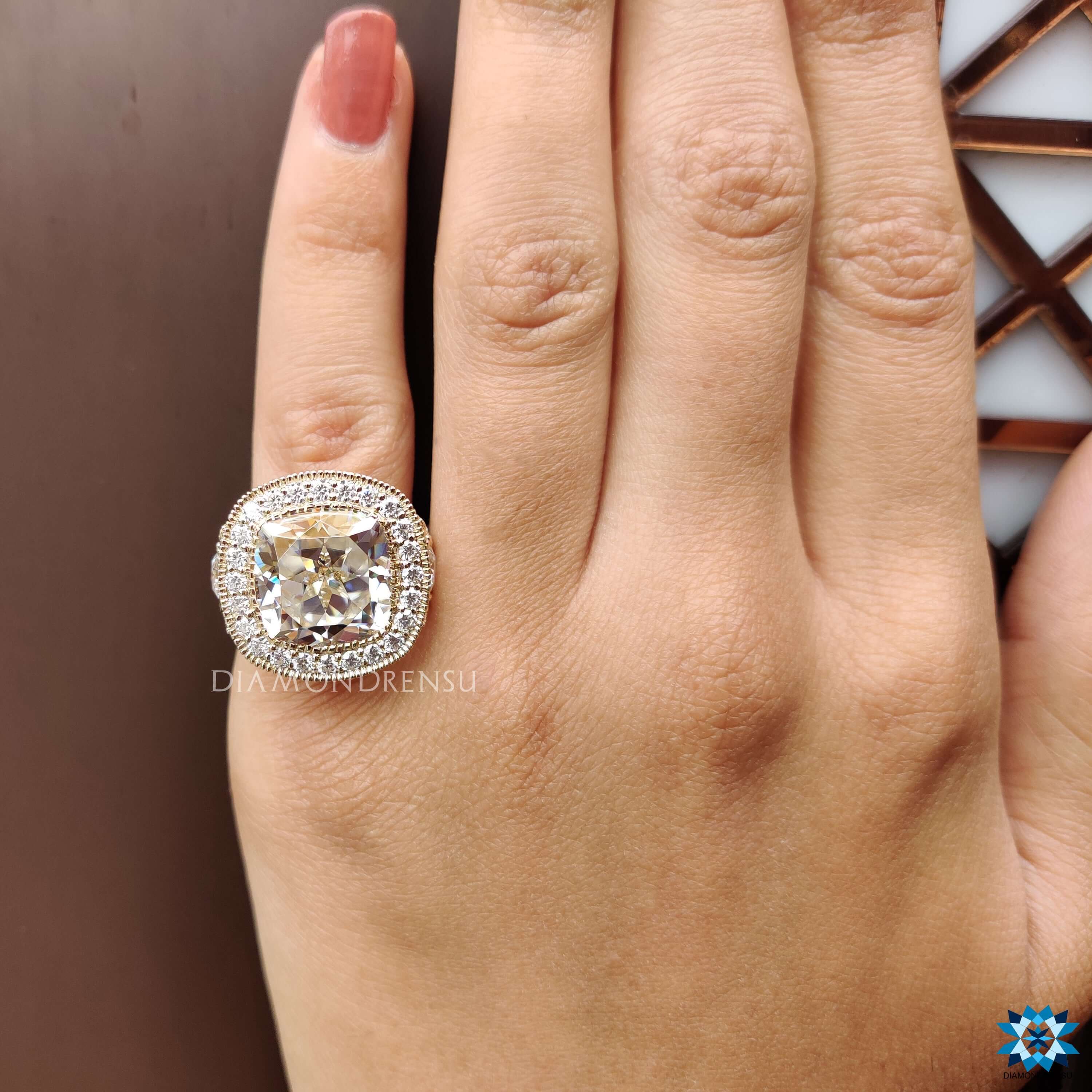 Yellow gold cushion cut moissanite ring with milgrain detailing.