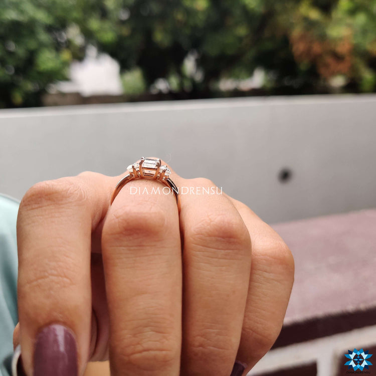 Custom engagement ring with emerald and moissanite stones.