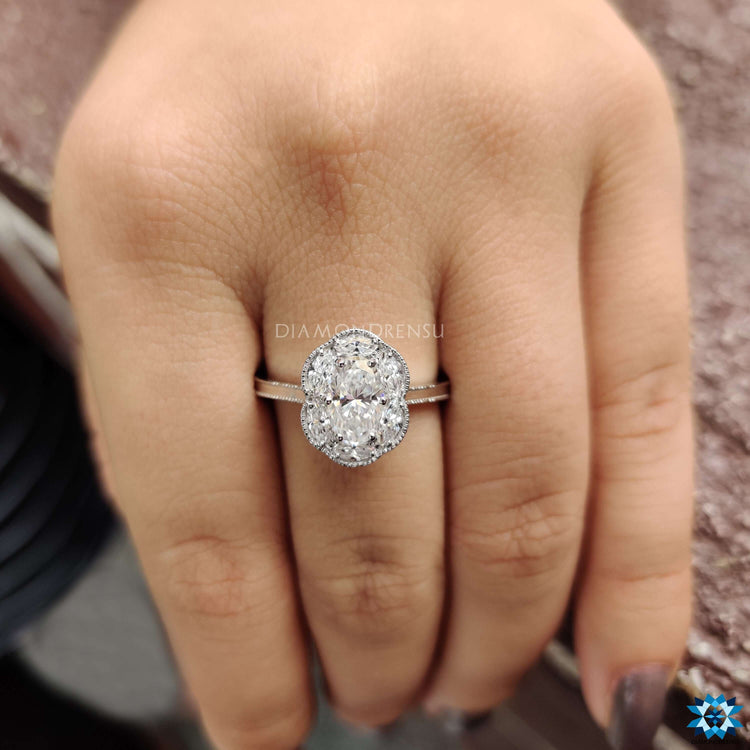 White gold halo engagement ring with oval moissanite center.