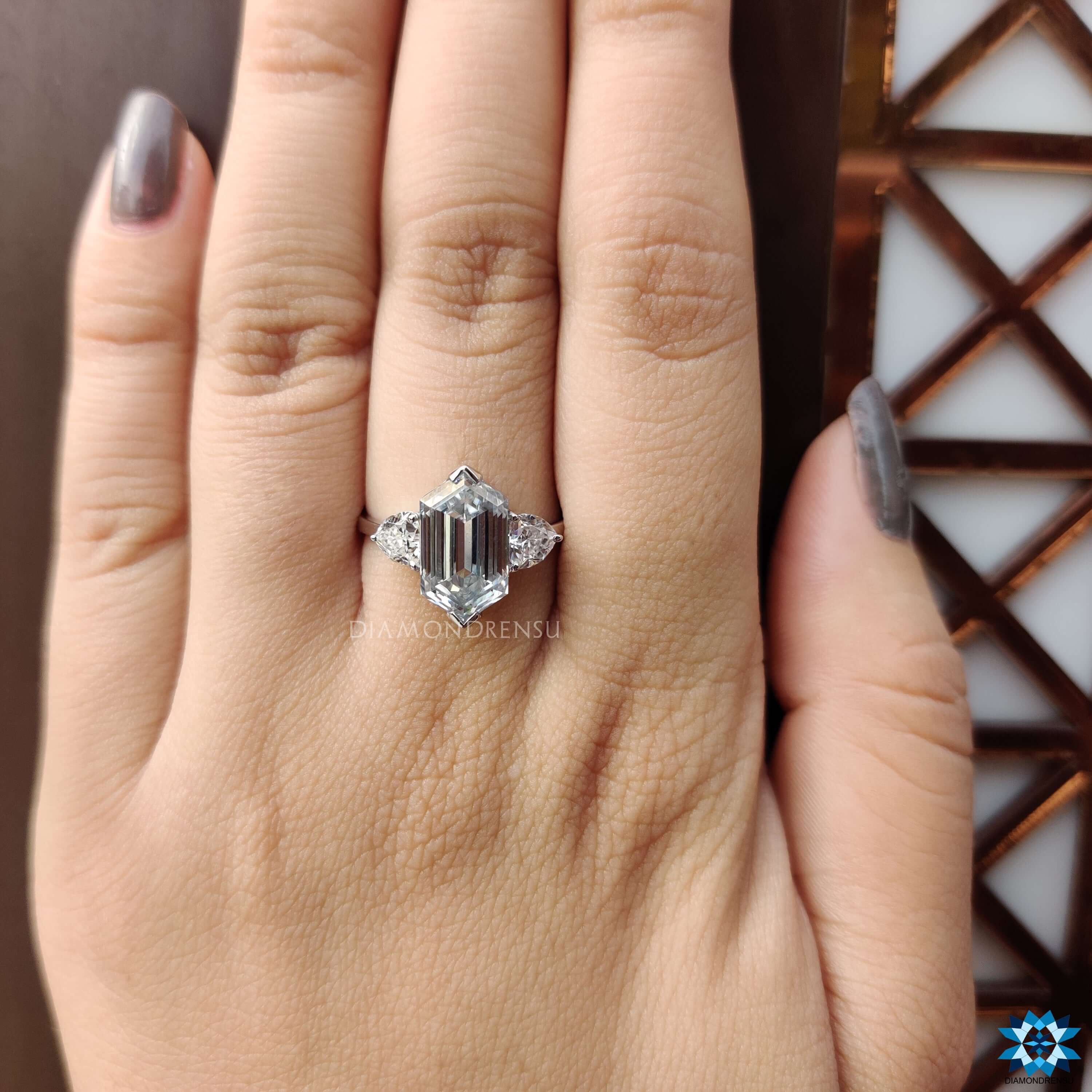 White gold three stone engagement ring with hexagon center stone.