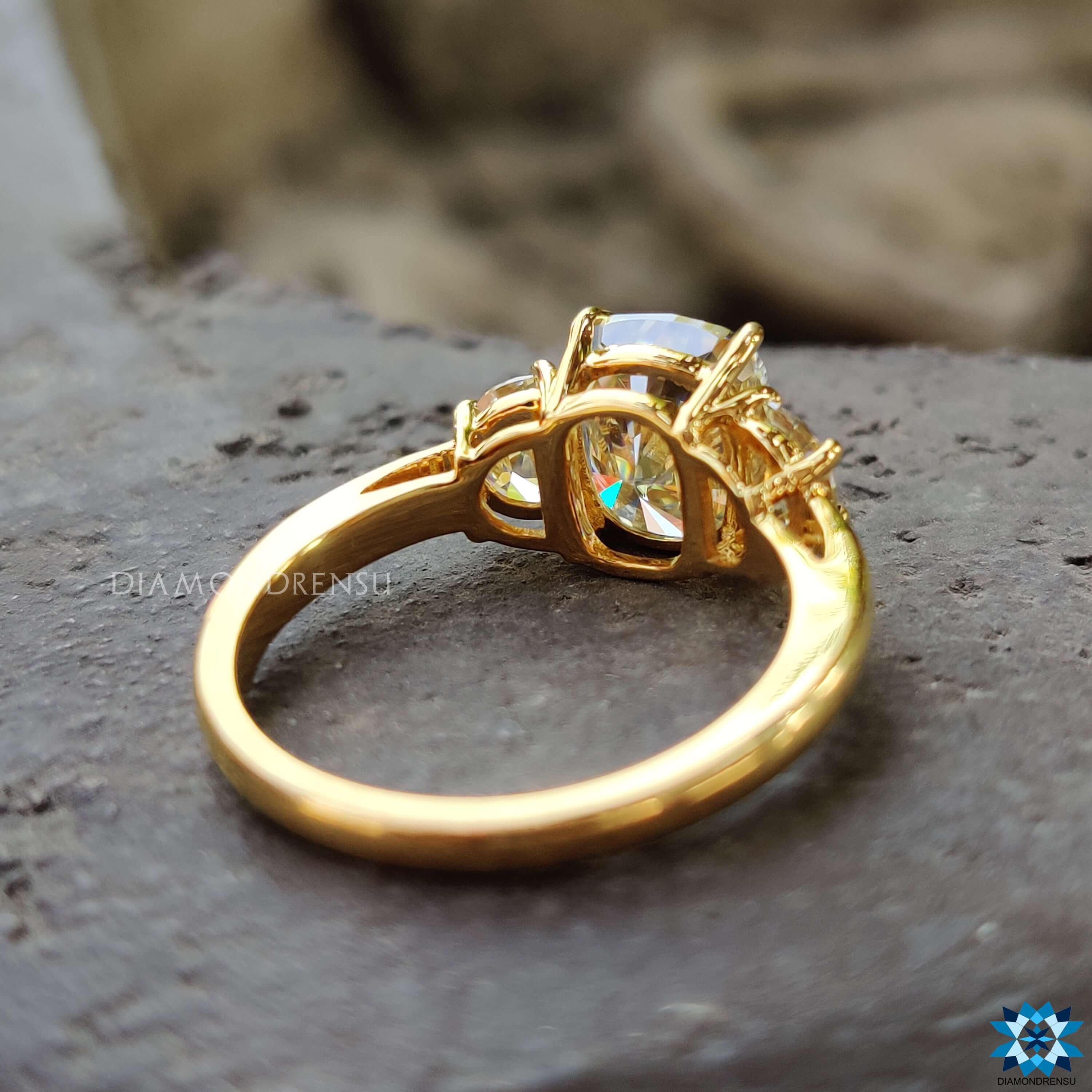 Light yellow moissanite three stone ring in yellow gold.