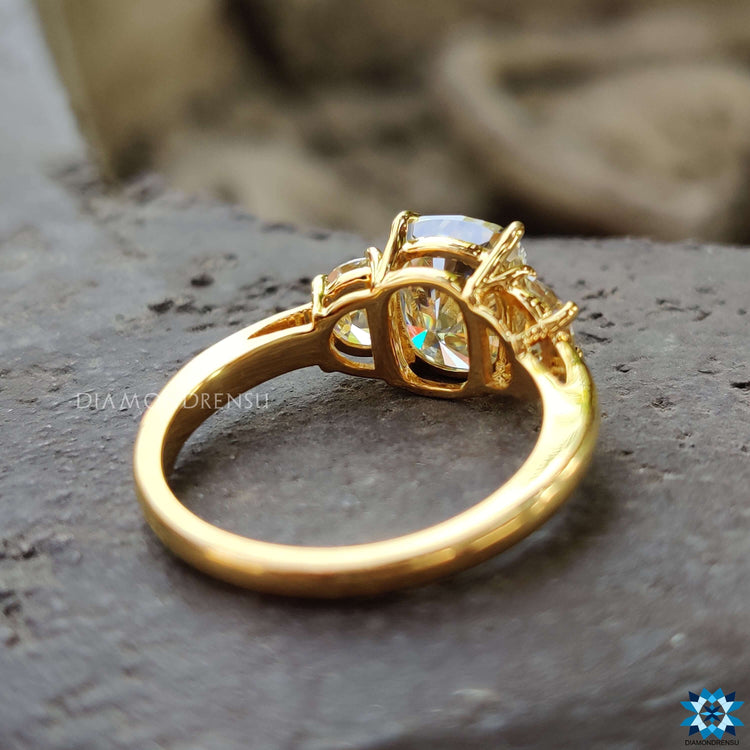 Light yellow moissanite three stone ring in yellow gold.