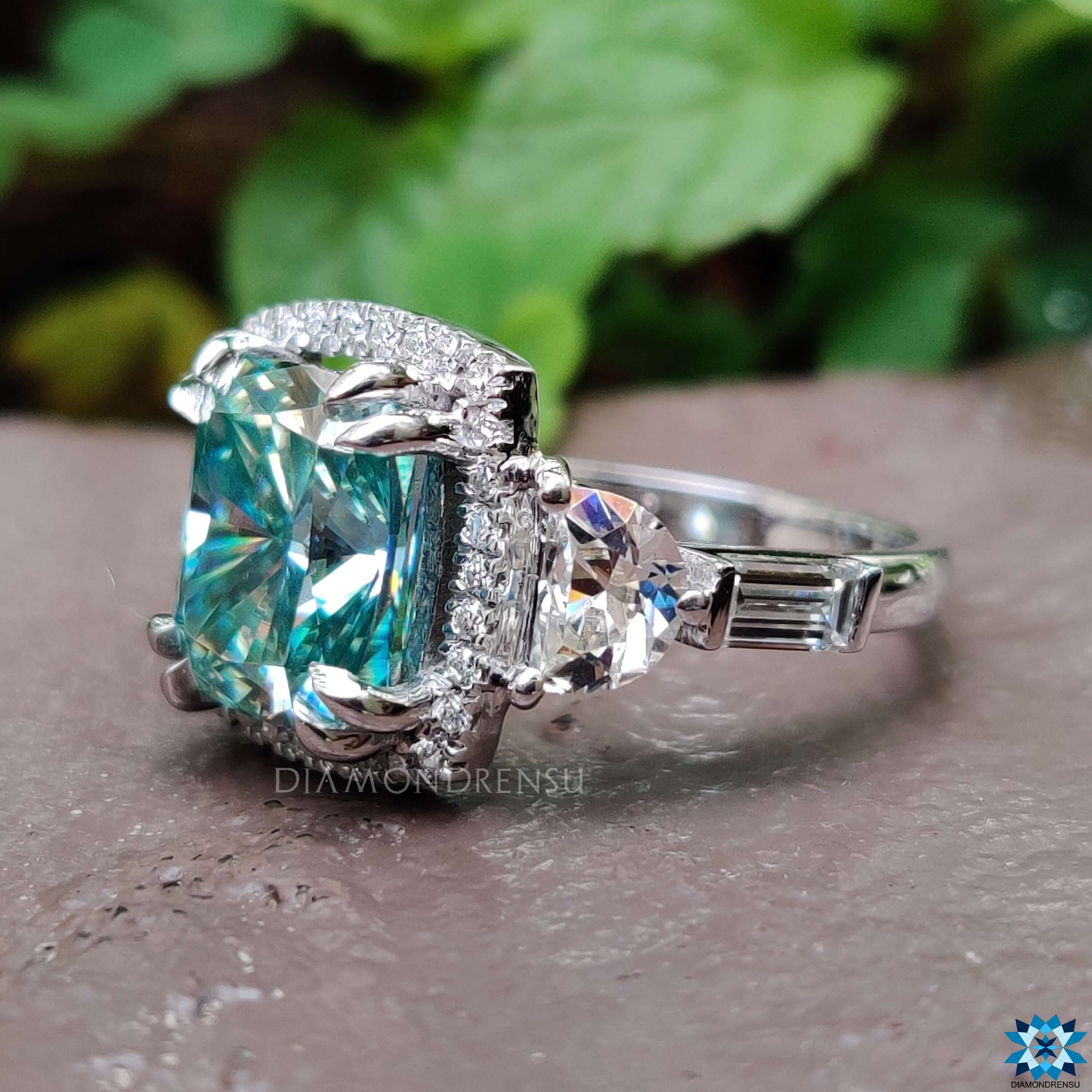 Cyan cushion moissanite ring with half moon and baguette accents.