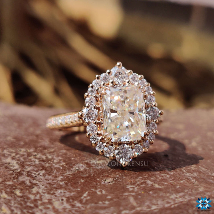 Vintage-inspired moissanite ring in rose gold with halo setting.