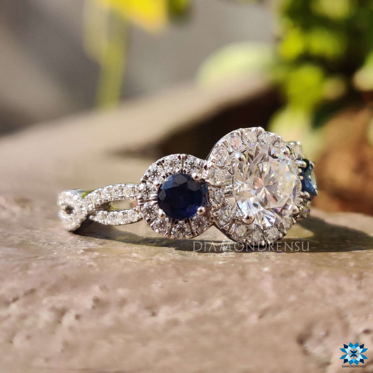 Round prong set moissanite ring with sapphire accent in white gold.