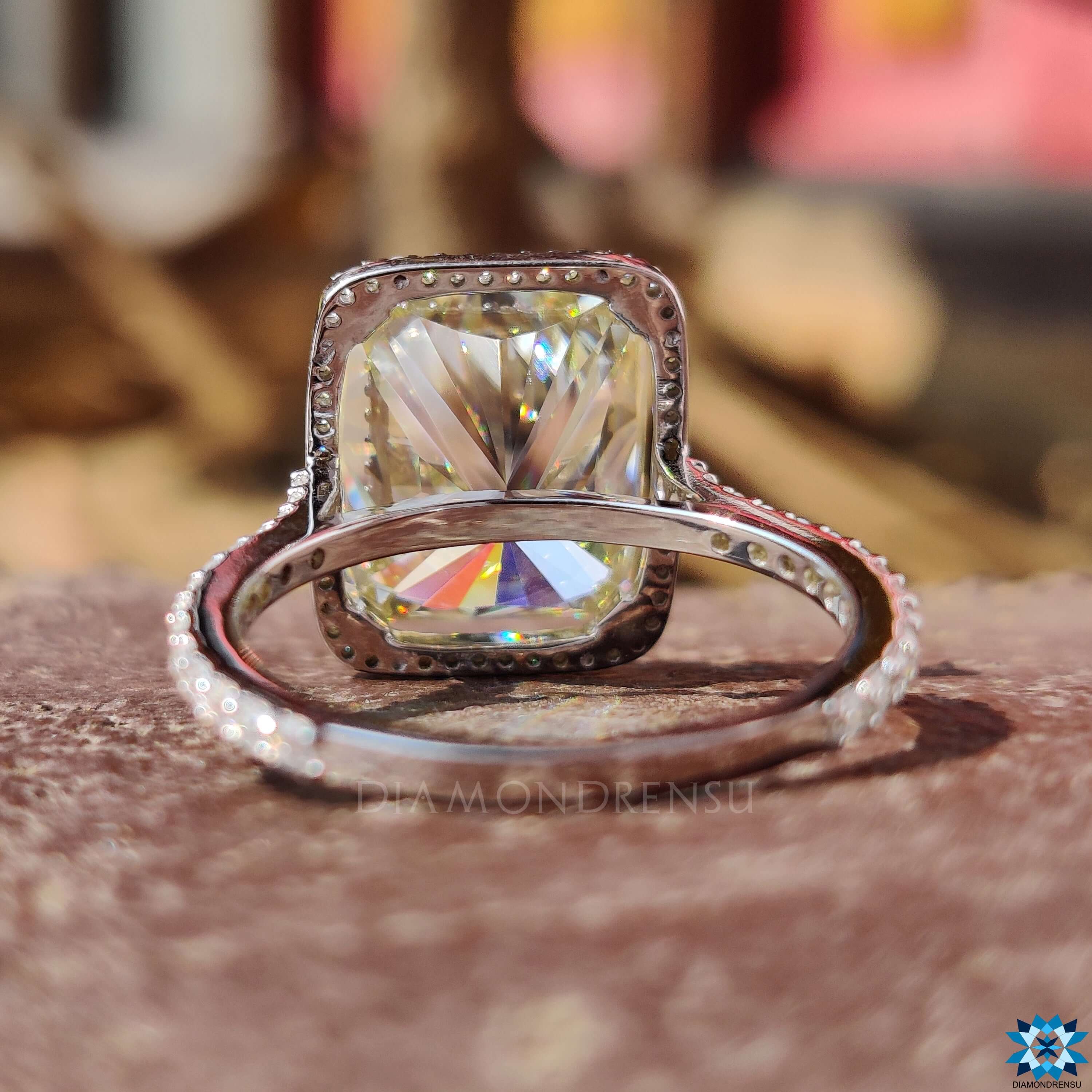 Cushion moissanite ring featuring a pave halo and band.