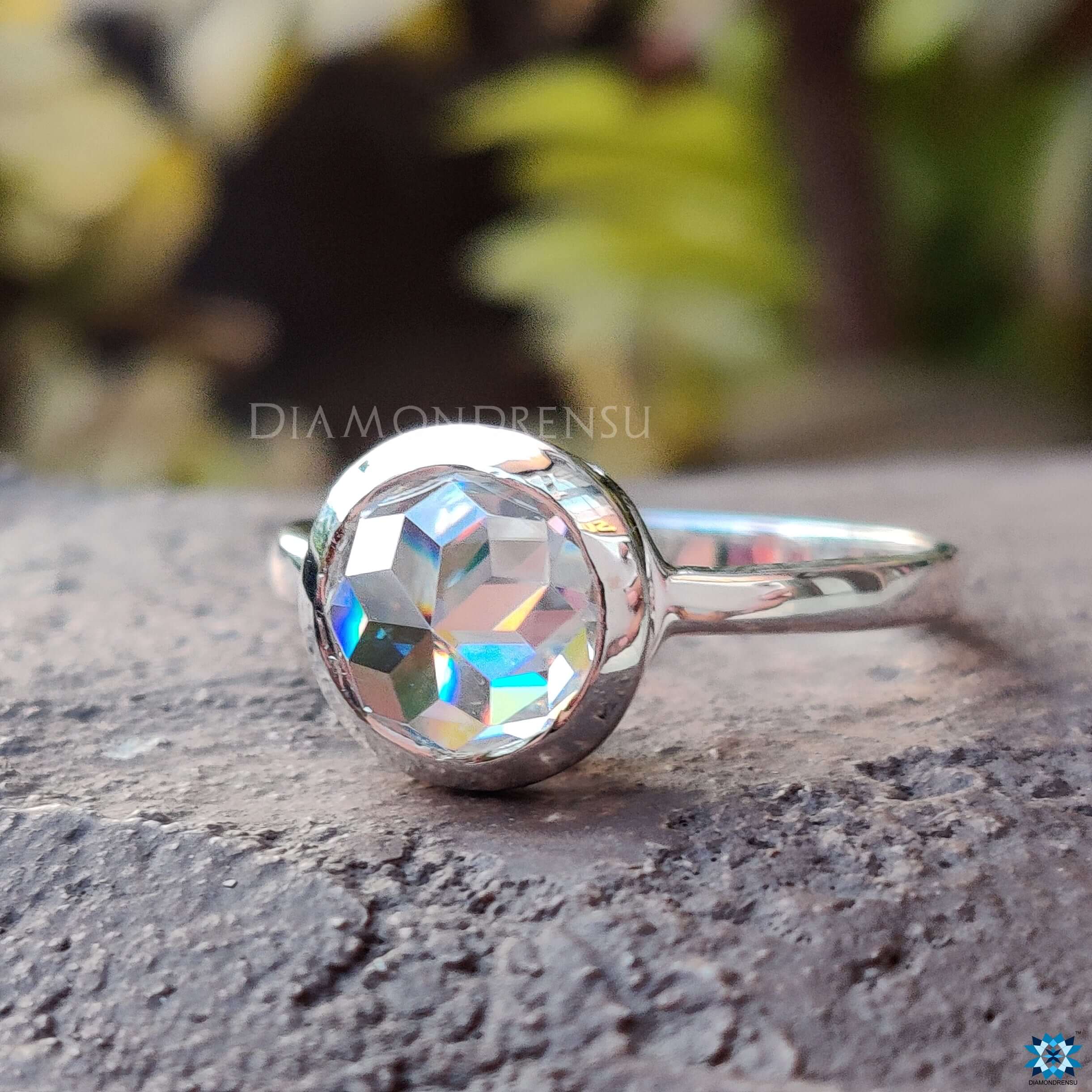 White gold Moissanite engagement ring with bezel-set round rose cut center.