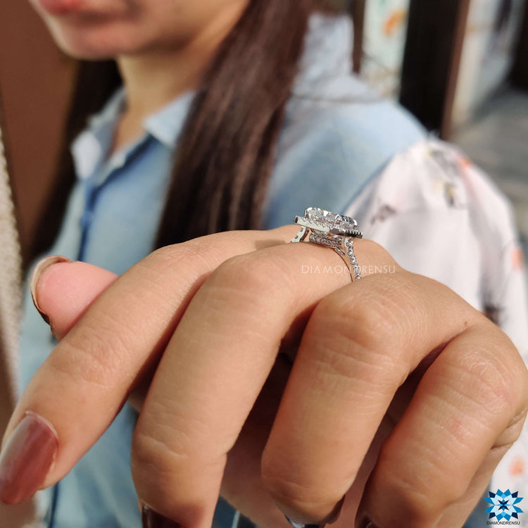 Moissanite engagement ring featuring a hidden halo and round side stones.
