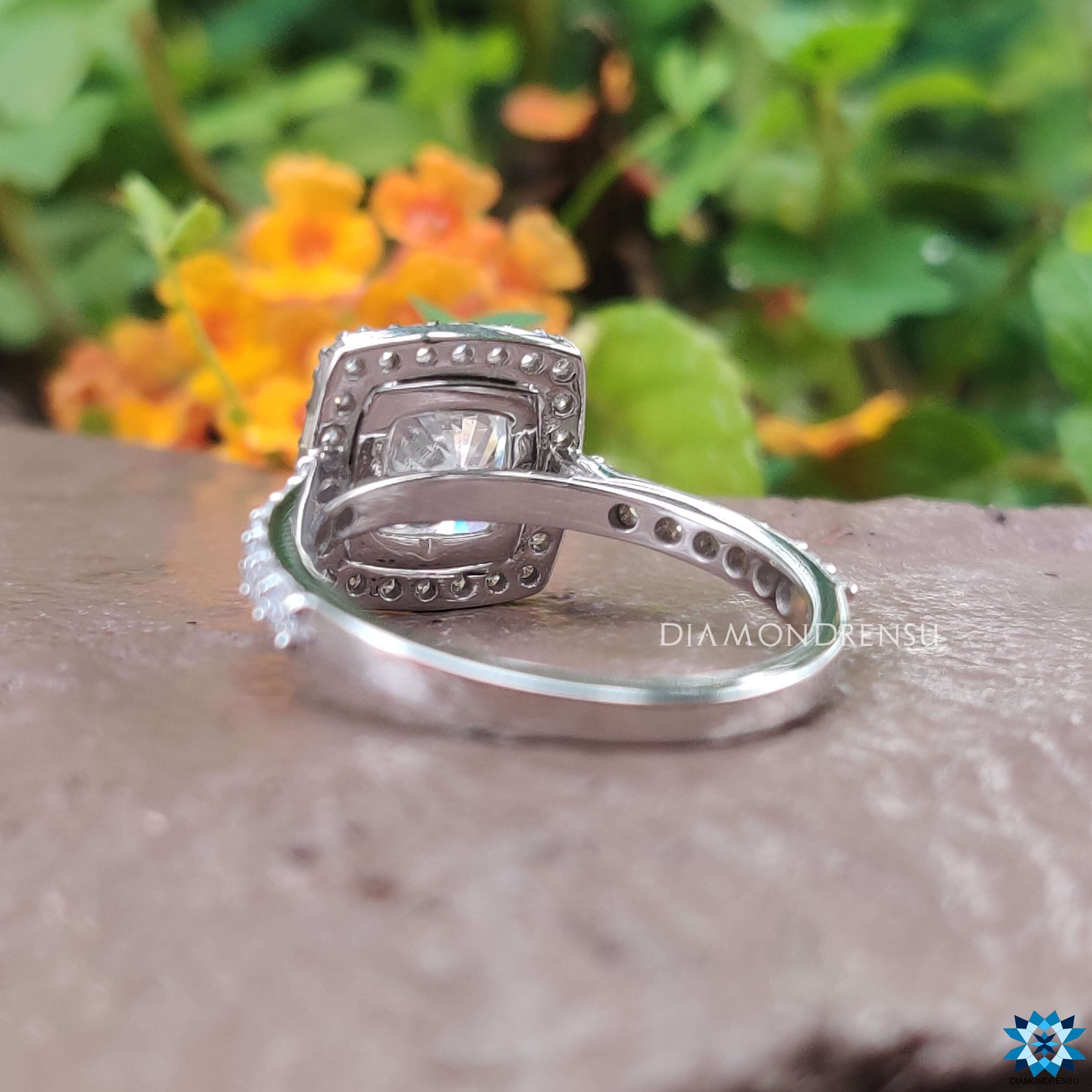 Cushion halo engagement ring in white gold with pavé detail.