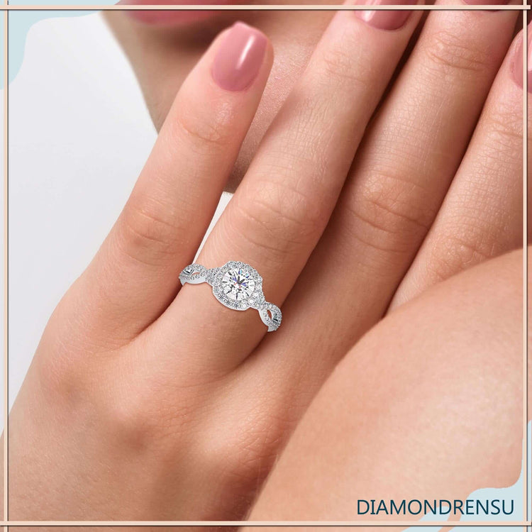 Round diamond centre stone with twisted band and halo setting.