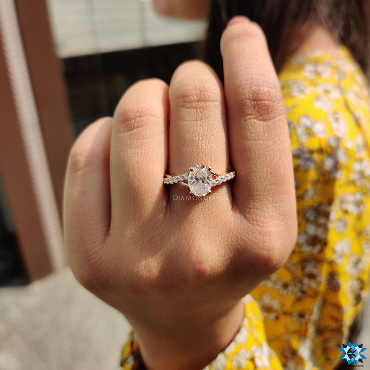 Oval twist engagement ring with pave round cut band.