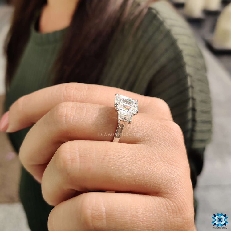 Buy moissanite ring with emerald centre and custom cathedral design.