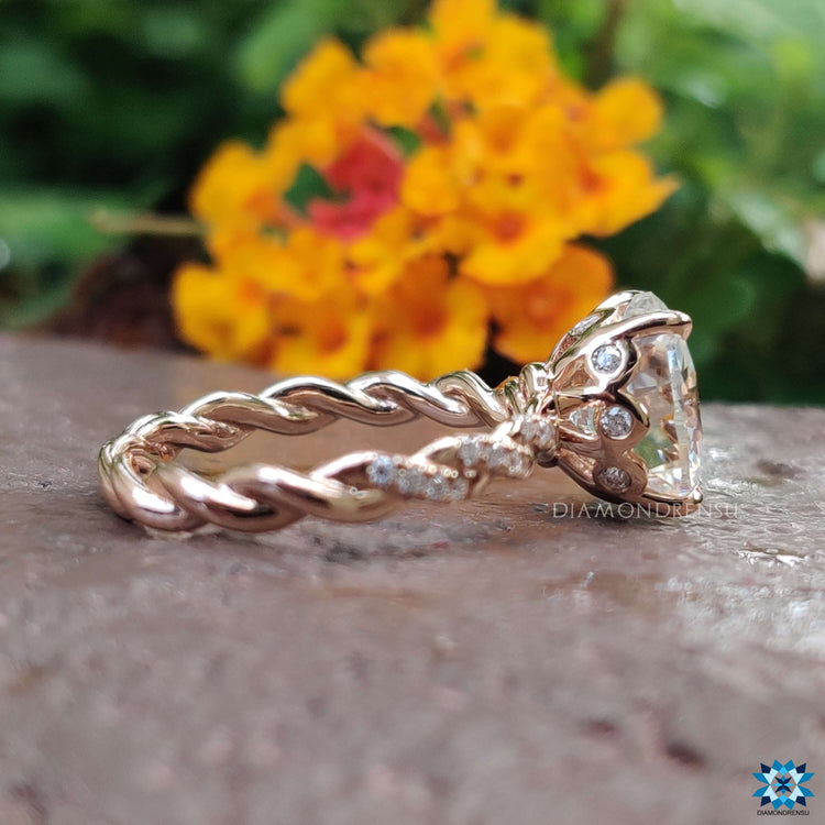 Oval moissanite ring with round accents and twisted shank design.