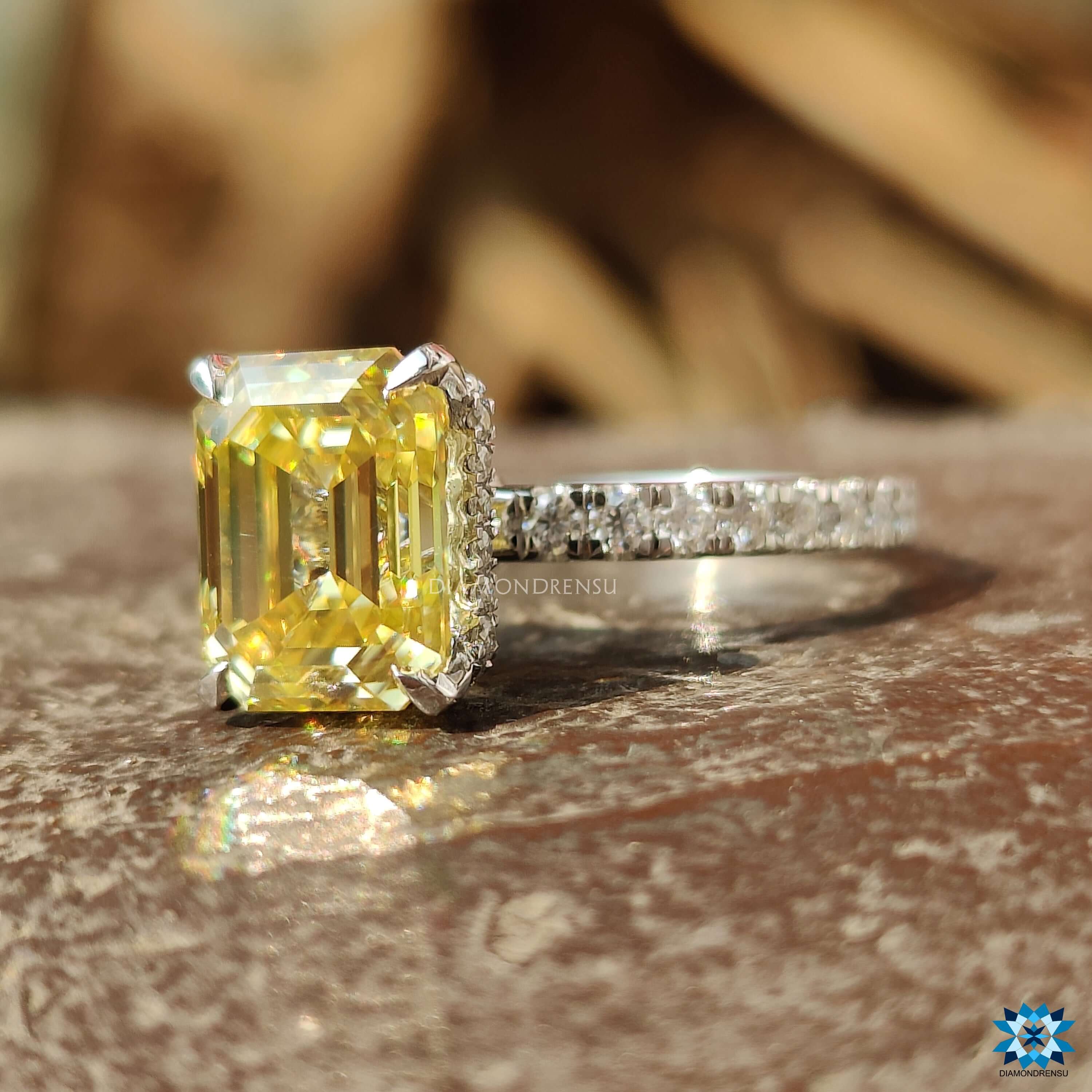 Yellow moissanite ring in emerald cut with 4 claw prong setting.