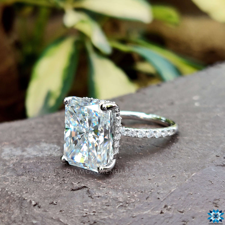 Four prong setting on elongated radiant cut moissanite ring.