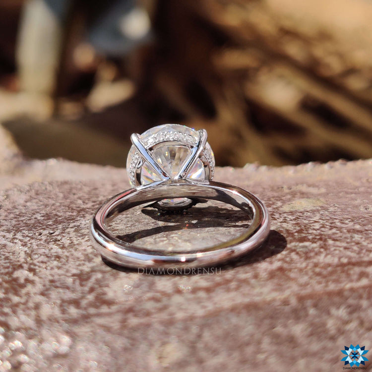 Round cut moissanite ring with hidden halo design.