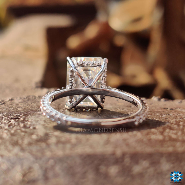 Custom engagement ring in white gold with hidden halo and emerald cut.
