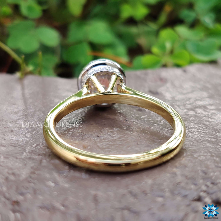 Round cut moissanite ring in yellow gold cathedral design.