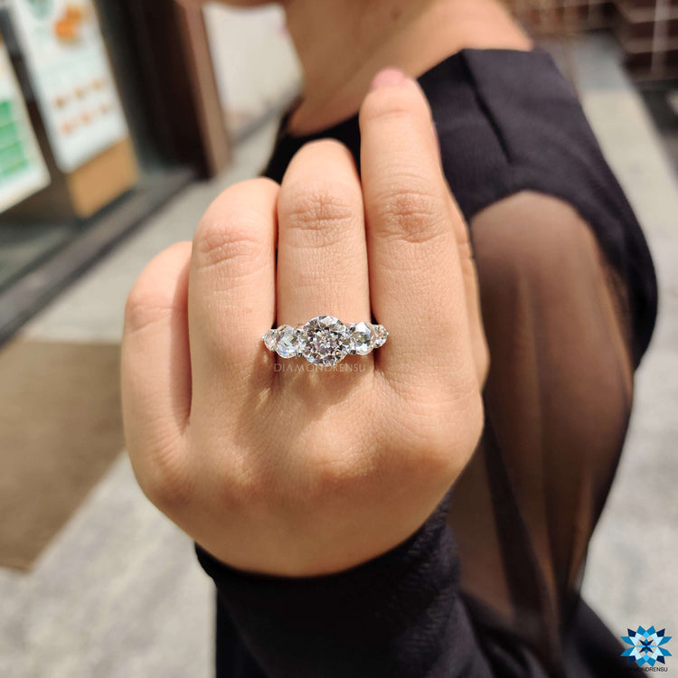 Jubilee cut center moissanite with round rose cut side stones.