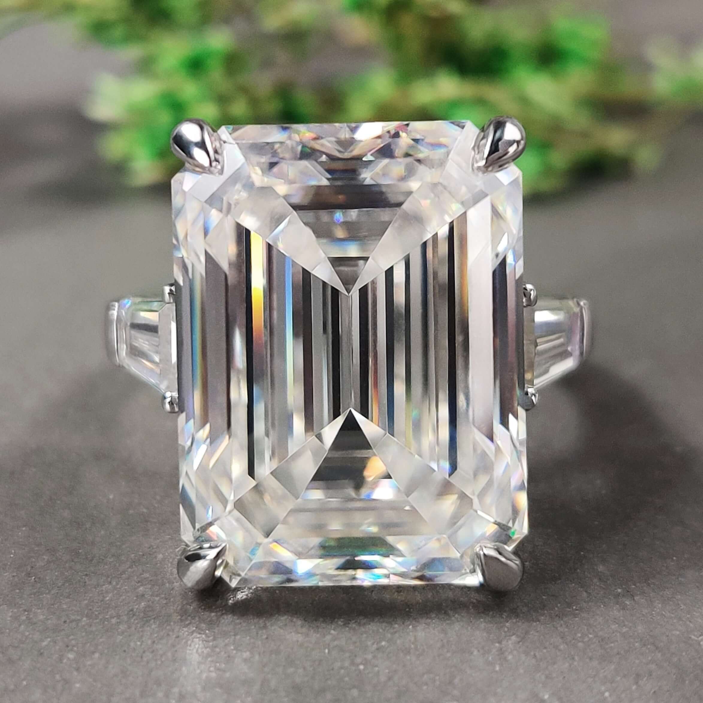 Three stone gold ring with emerald cut center.