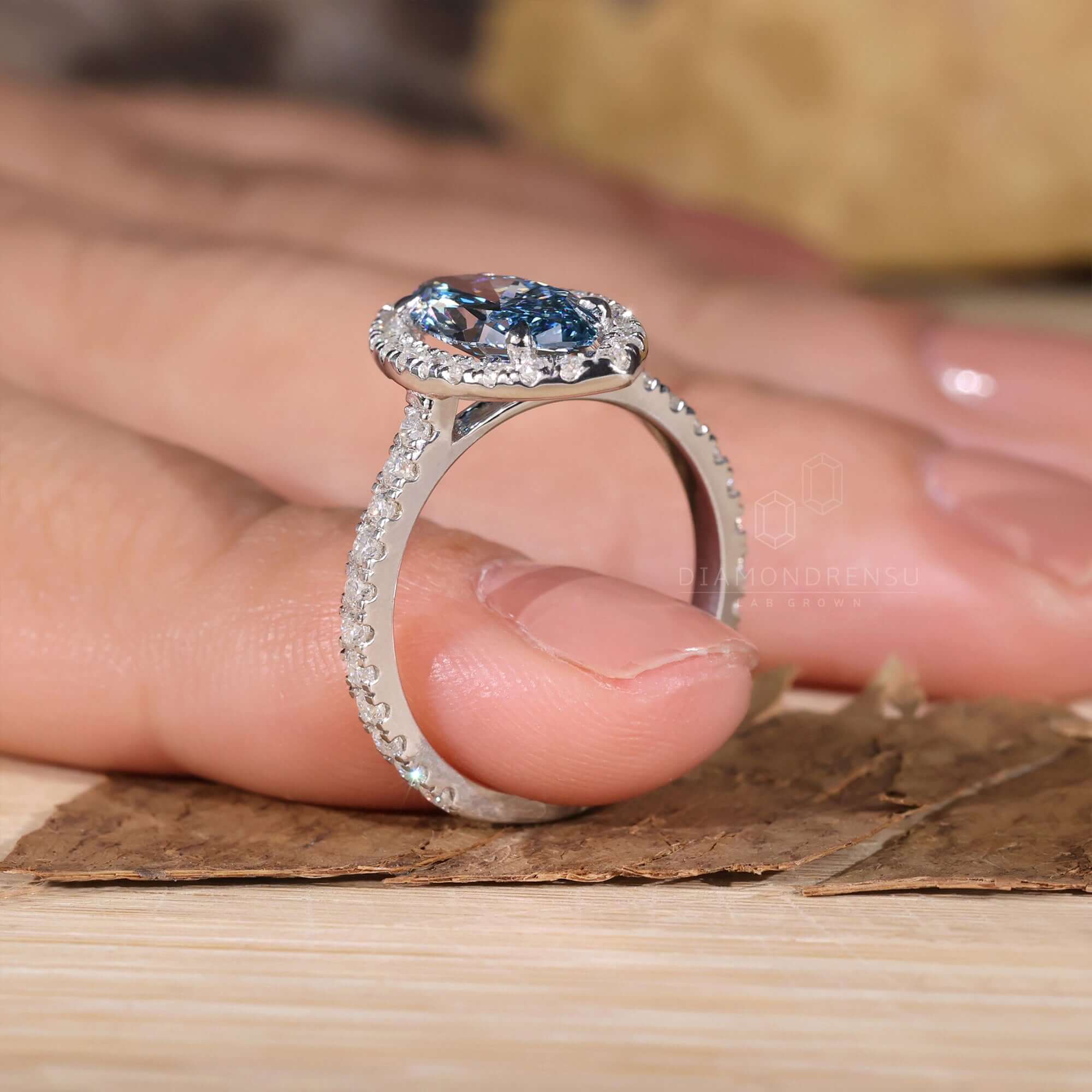 Blue and diamond ring featuring a marquise engagement ring halo style.