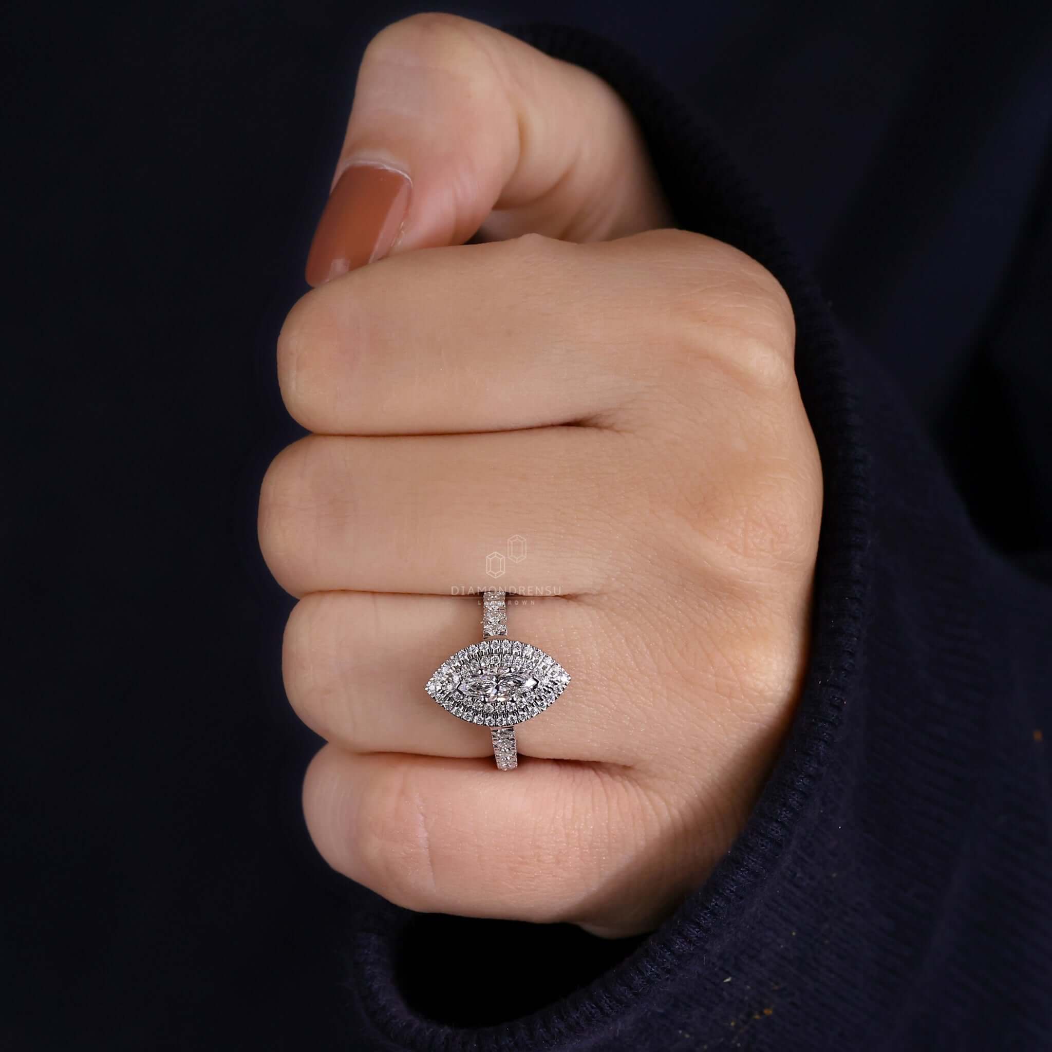 Marquise cut diamond set in a pave diamond ring with a cathedral setting style.