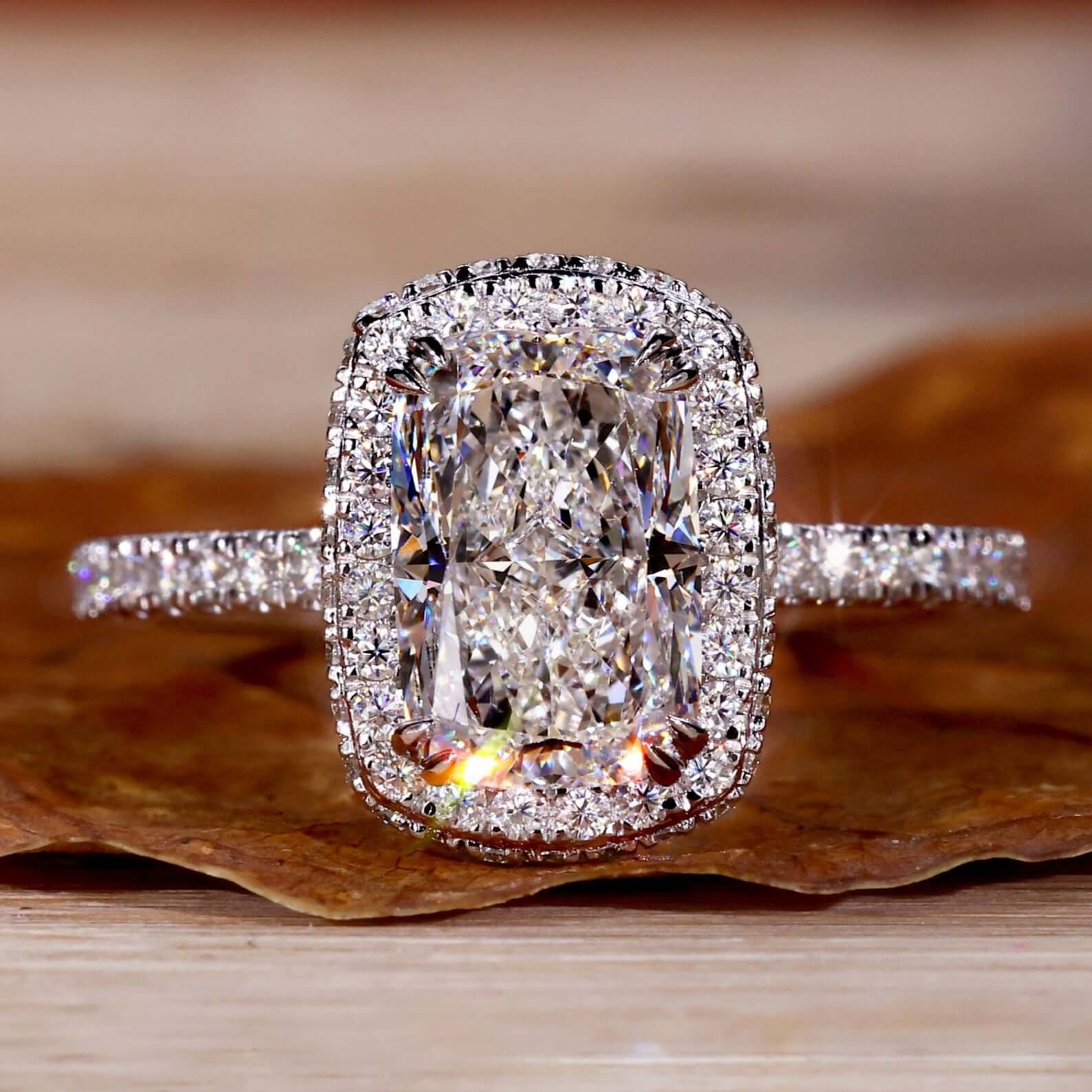 Cushion engagement ring with halo and double claw prong in a pave diamond ring design for timeless elegance.