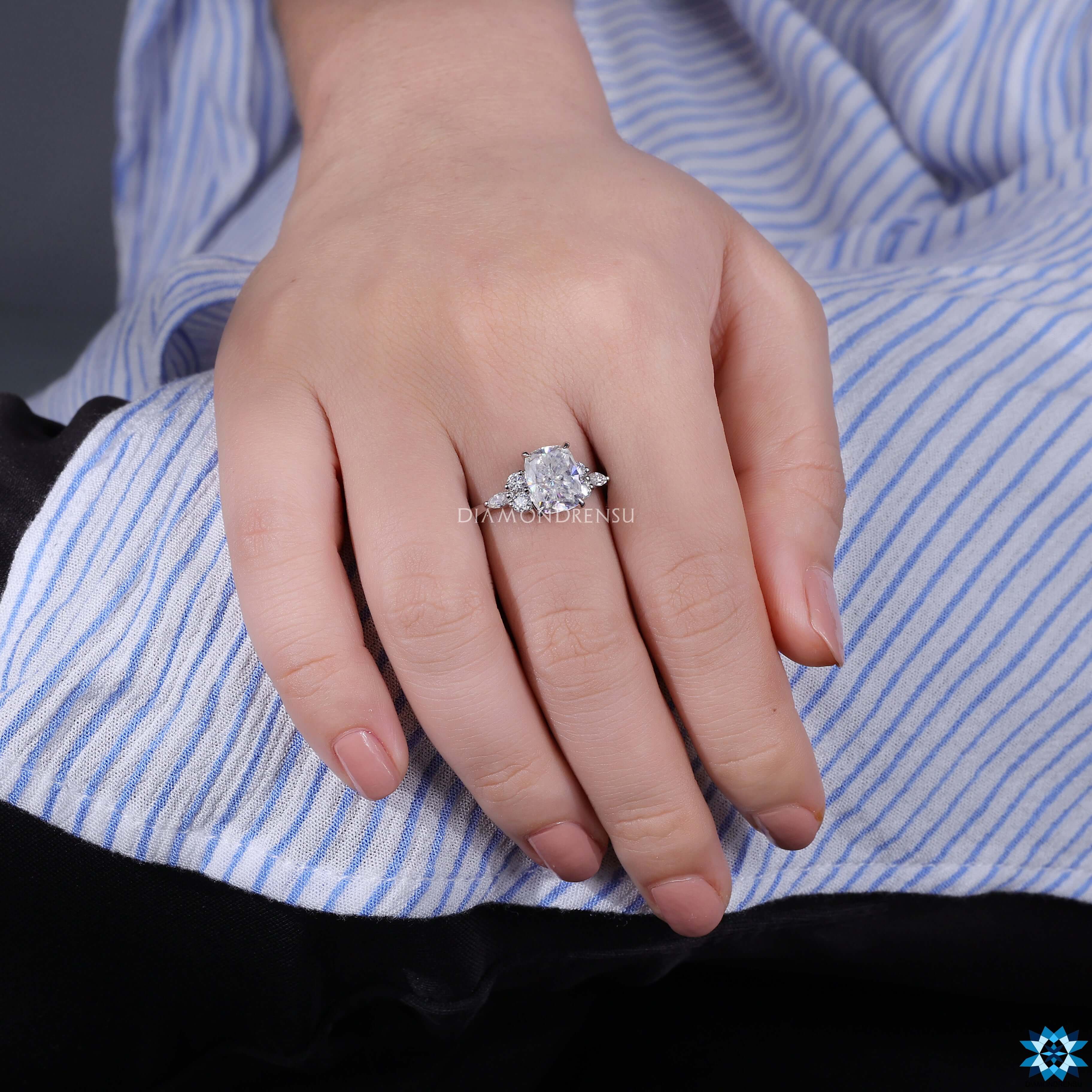 White gold engagement ring with cushion center and 7 stone layout.