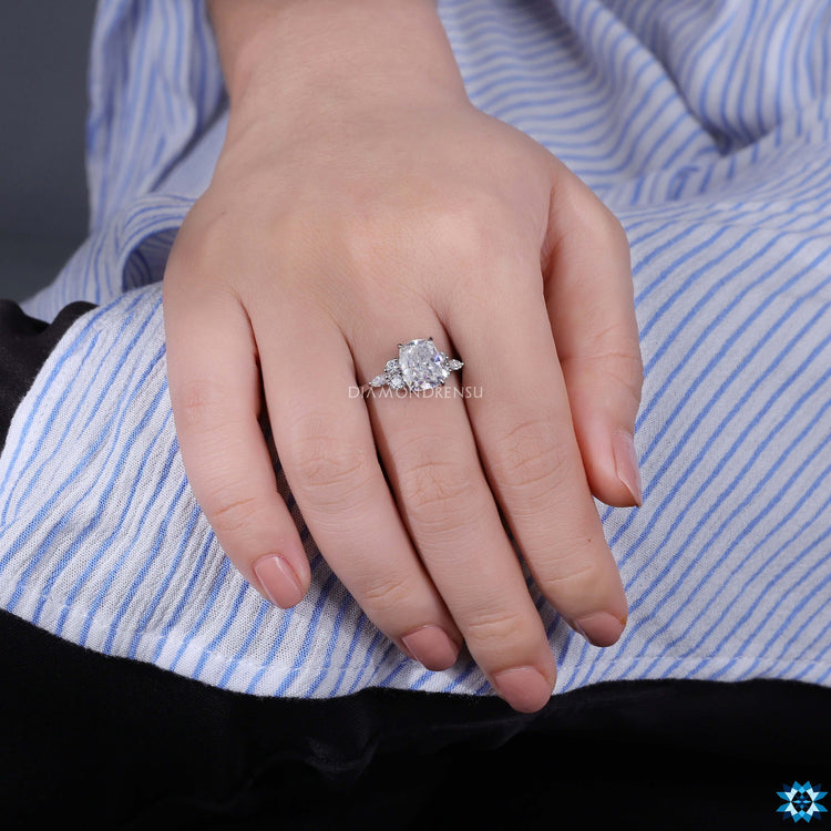 White gold engagement ring with cushion center and 7 stone layout.