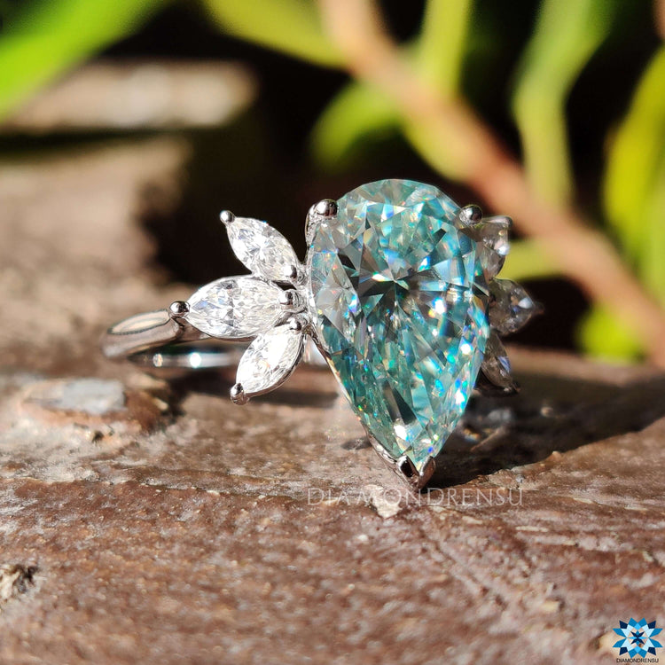 Pear shaped blue moissanite ring in prong setting.