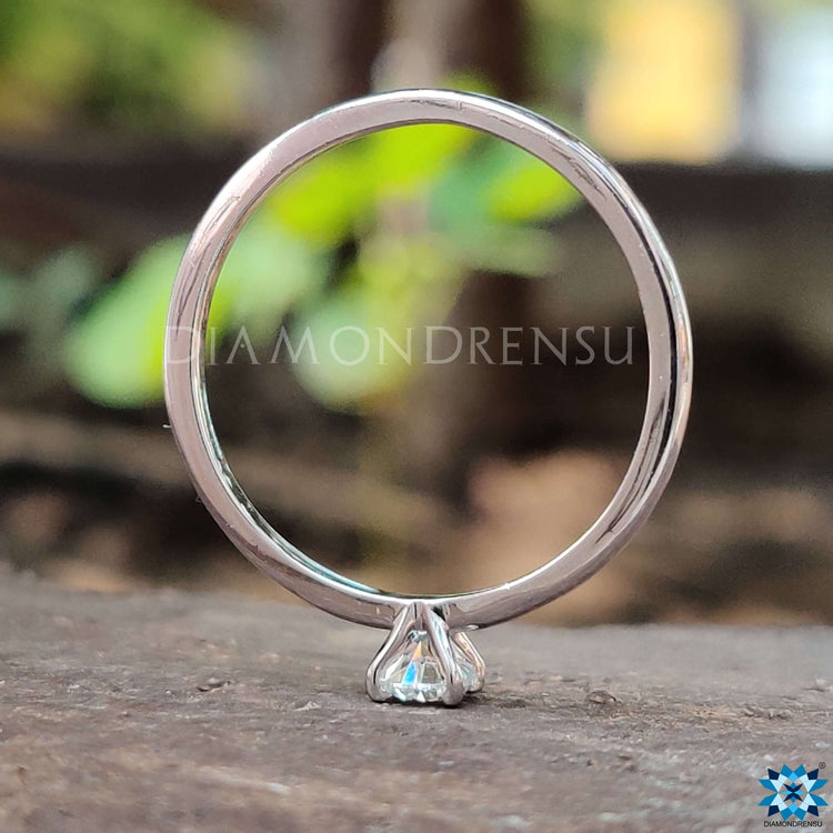 Simple round cut moissanite solitaire ring.