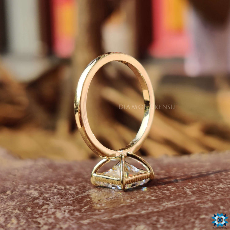 Custom engagement ring featuring a princess cut moissanite and 4 claw prongs.